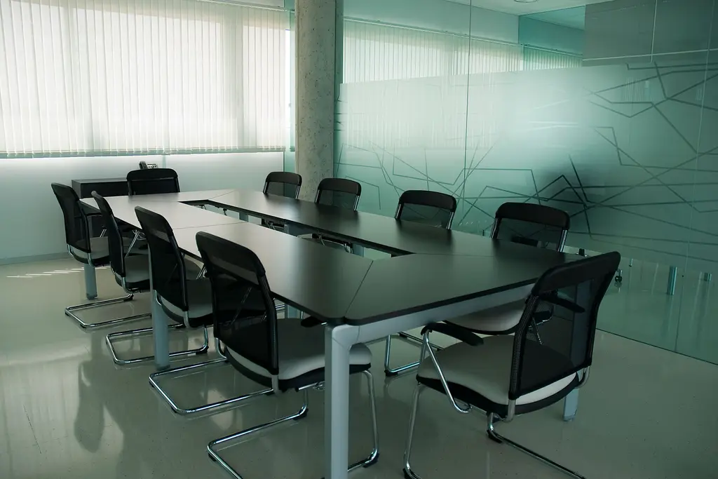 Vergaderruimte achter een glazen wand met een decoratief lijnenpatroon